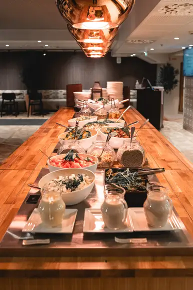 Lähikuva Burgergbuffet annoksesta. Lautasella itse kasattu hampurilainen, salaattia ja ranskalaisia.