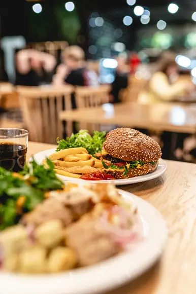 Lähikuva Burgergbuffet annoksesta. Lautasella itse kasattu hampurilainen, salaattia ja ranskalaisia.