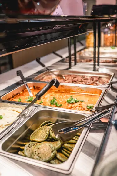 Lähikuva siipibuffet annoksesta. Lautasella ristikkoperunoita ja wingsejä