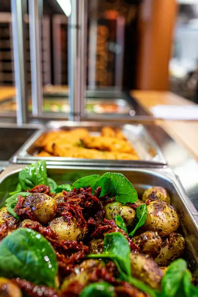 Lähikuva Burgergbuffet annoksesta. Lautasella itse kasattu hampurilainen, salaattia ja ranskalaisia.