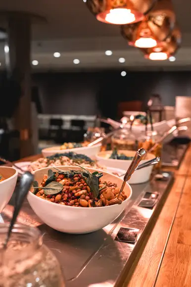 Lähikuva siipibuffet annoksesta. Lautasella ristikkoperunoita ja wingsejä