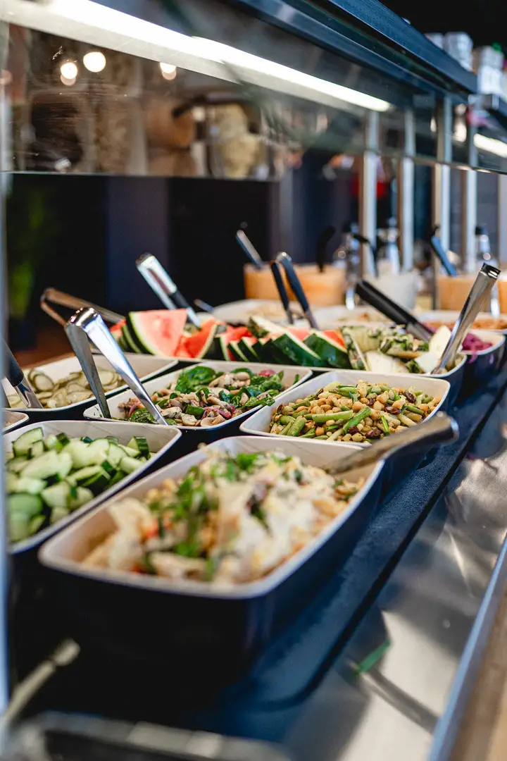 Lähikuva Burgergbuffet annoksesta. Lautasella itse kasattu hampurilainen, salaattia ja ranskalaisia.