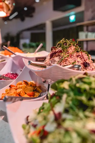 Lähikuva Burgergbuffet annoksesta. Lautasella itse kasattu hampurilainen, salaattia ja ranskalaisia.