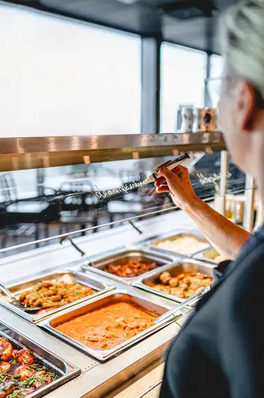 Lähikuva Burgergbuffet annoksesta. Lautasella itse kasattu hampurilainen, salaattia ja ranskalaisia.