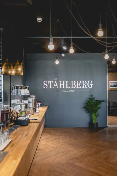 Lähikuva lounasannoksesta, jossa Ståhlbergin omia lihapullia kermakastikkeessa, krutonkeja, slaattia ja perunamuusia. Taustalla lasi kotikaljaa ja lautanen jolla hampurilainen ja ranskalaisia burgerbuffasta.