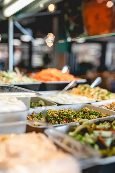 Lähikuva Burgergbuffet annoksesta. Lautasella itse kasattu hampurilainen, salaattia ja ranskalaisia.