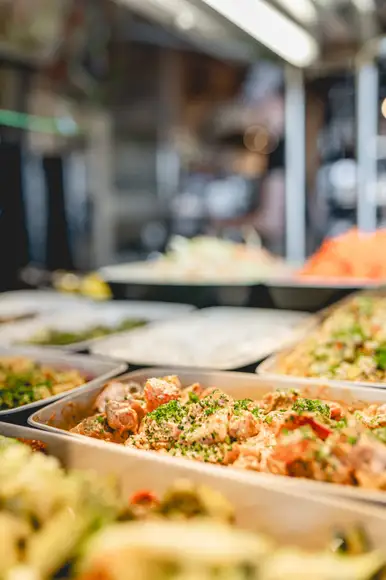 Lähikuva siipibuffet annoksesta. Lautasella ristikkoperunoita ja wingsejä