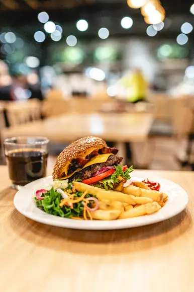 Lähikuva Burgergbuffet annoksesta. Lautasella itse kasattu hampurilainen, salaattia ja ranskalaisia.